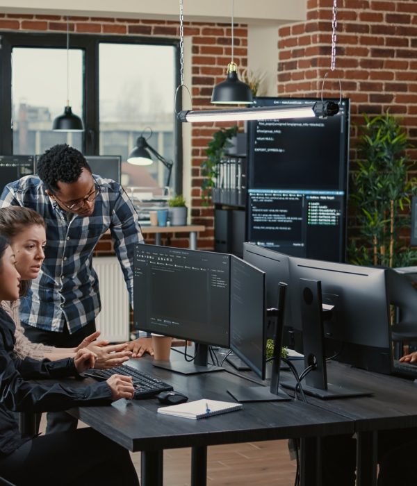 Junior dev programmers collaborating on group project compiling algorithm asking senior developer